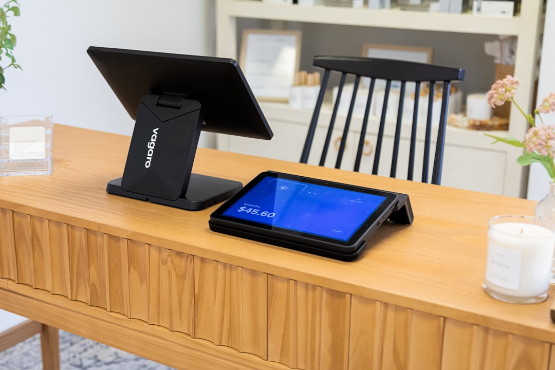 At the front desk of a beautifully lit business, the Vagaro PayPro Duo sits on a warm wooden desk to checkin and checkout clients. The business has plenty of natural light with white, warm, and black accents that gives a welcoming feeling.